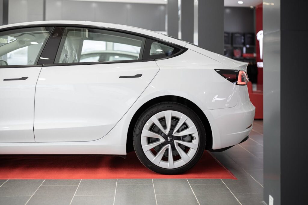 Hvit Tesla sett fra siden i et showroom